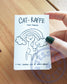 a small paper booklet features a drawing of a cat's head on a giraffe's body and the text: Cat-Raffe and Friends a mini coloring zine by Jessica Anecito